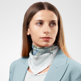 Woman wearing a patterned scarf with a light gray background